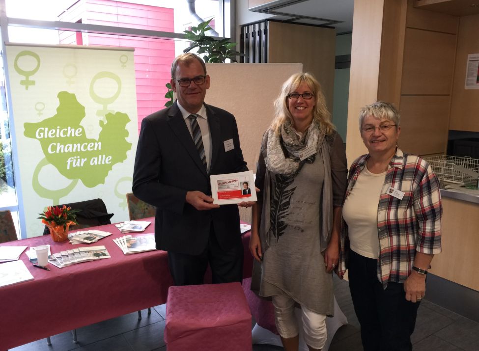 Foto: Verbandsbürgermeister Lothar Röser, Gleichstellungsbeauftragte Susanne Christ und Doris Eyl-Müller vor ihrem Stand. 