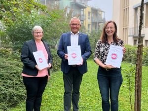 Die Gleichstellungsbeauftragten Beate Ullwer (links) und Daniela Kiefer (rechts) sowie Landrat Achim Hallerbach mit dem neuen Reader der Fachtagung. 