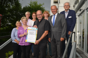 Foto: (v.l.) Rosi Pfaffhausen, stellv. PDL, Karla Meirich, PDL, Wohnbereichs- und Sozialdienstlleitungen sowie Dr. Ulrich Kettler, Kreisbeigeordneter Achim Hallerbach und Einrichtungsleiter Bernard Stammer laden zur Veranstaltung „Demenz hat viele Gesichter“ herzlich ein.