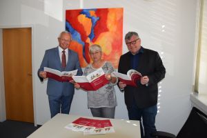 Landrat Achim Hallerbach mit der Gleichstellungsbeauftragten des Landkreises Doris Eyl-Müller und dem 1. Kreisbeigeordneten Michael Mahlert beim ersten Blick in die neue Broschüre der Arbeitsgemeinschaft der kommunalen Gleichstellungsbeauftragten des Landes Rheinland-Pfalz