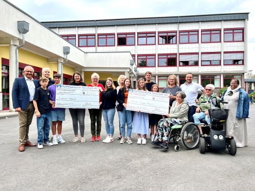 von links: Landrat Achim Hallerbach, Sabine Hacker (Schulleiterin), Jenny Jung (Ehrenamtliche Kindertrauerbegleiterin Neuwieder Hospiz), Beate Christ (Koordinatorin Trauerbegleitung Neuwieder Hospiz), Gabi Krautscheid (Gruppenleiterin DMSG) 4. v. re. und Bengjamin Bajraktari (Stellv. Schulleiter) 3. v. re., mit den Schülerinnen und Schülern bei der Spendenübergabe an der Realschule Plus in Asbach. Foto: Martin Boden (Kreisverwaltung Neuwied) 